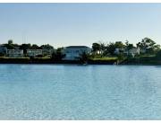 Vendo terreno en Aqua Village con área verde atrás.